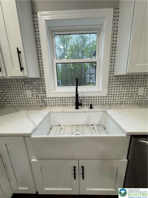 211 Maxatawny Dr, Coolbaugh Twp, PA 18347 - kitchen view of tasteful backsplash, white cabinetry, and light stone countertops