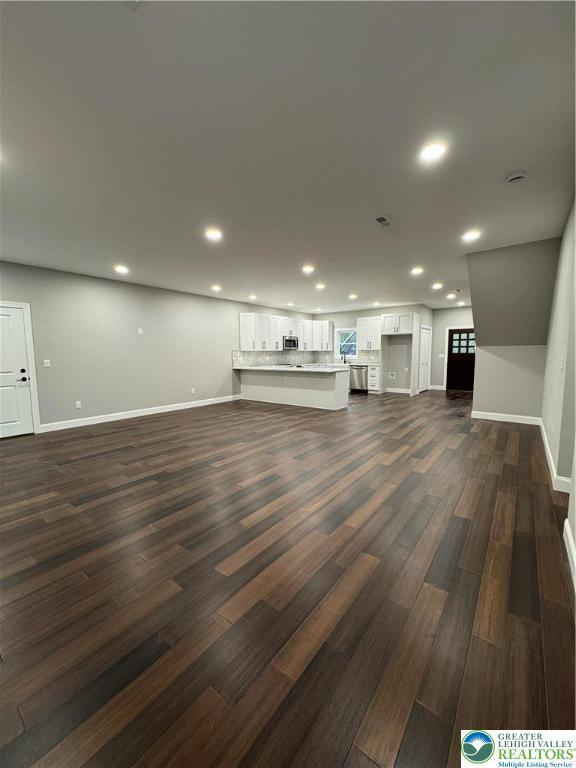 211 Maxatawny Dr, Coolbaugh Twp, PA 18347 - unfurnished living room featuring dark wood-type flooring, recessed lighting, and baseboards
