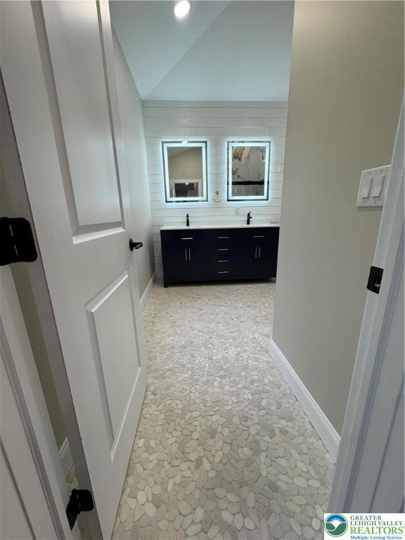 211 Maxatawny Dr, Coolbaugh Twp, PA 18347 - full bath featuring stone flooring, double vanity, lofted ceiling, and baseboards