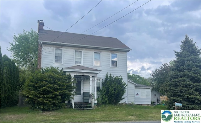 view of front of property featuring a chimney, a front yard, and entry steps