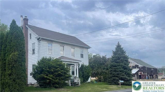 view of home's exterior with a chimney and entry steps
