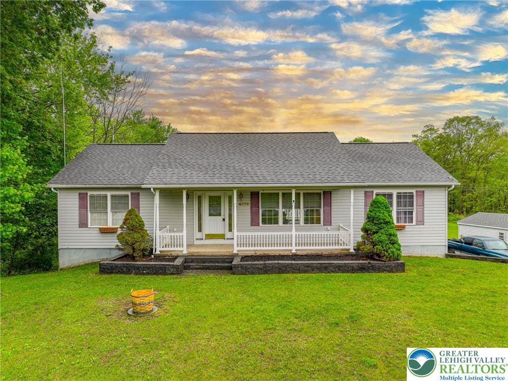 view of front of house featuring a porch, roof with shingles, and a front lawn