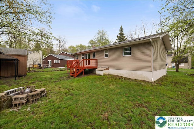1918 Horseshoe, Coolbaugh Twp, PA 18466 - rear view of house with a wooden deck, a yard, a storage unit, and an outbuilding