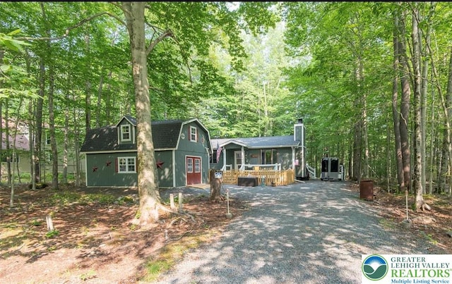 266 Maxatawny Dr, Coolbaugh Twp, PA 18347 - view of front of house featuring an outbuilding, a chimney, a gambrel roof, a deck, and a forest view