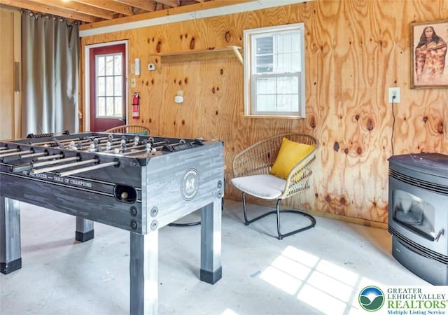 266 Maxatawny Dr, Coolbaugh Twp, PA 18347 - recreation room featuring concrete floors, wooden walls, and a wood stove