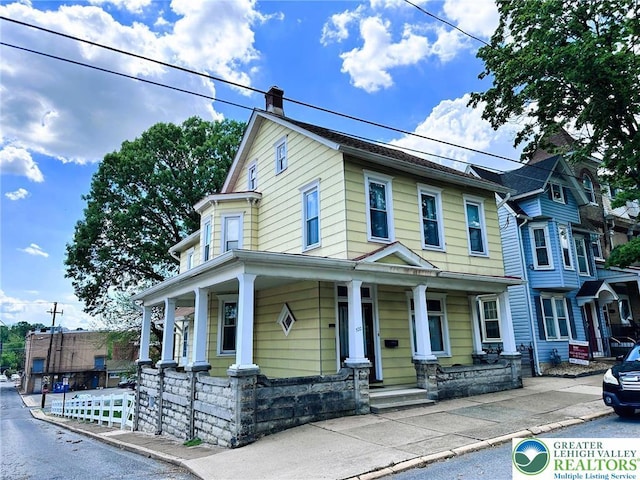 520 2nd St, Catasauqua Borough, PA 18032 - view of front facade featuring a porch, a chimney, stone siding, and fence