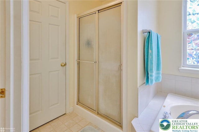 bathroom featuring healthy amount of natural light, a stall shower, and a bath