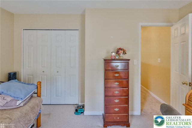 bedroom with carpet, a closet, and baseboards