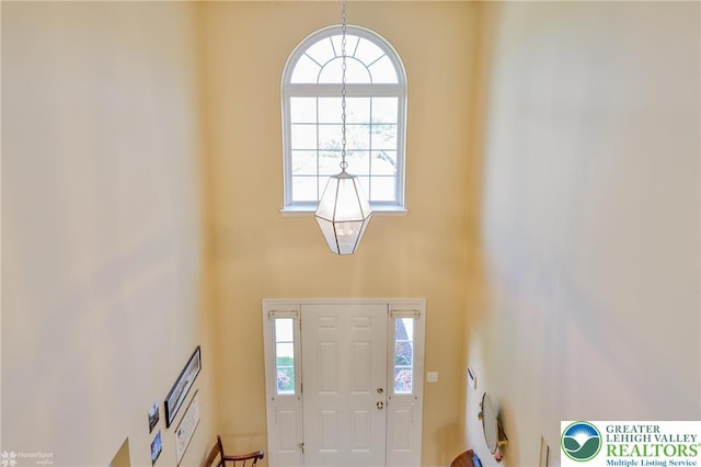 entryway with a high ceiling and a chandelier