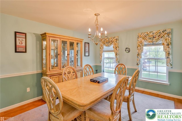 dining area featuring a chandelier, plenty of natural light, and baseboards