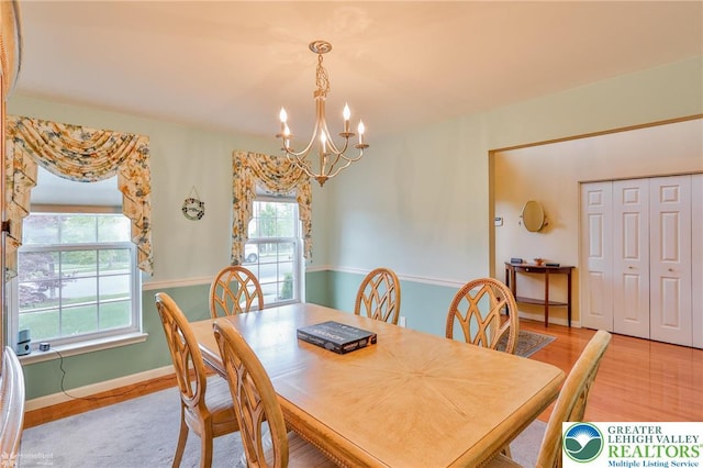 dining space with a chandelier, light wood-style floors, and baseboards