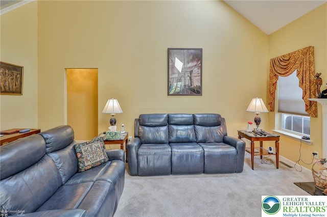 carpeted living room featuring high vaulted ceiling and baseboards