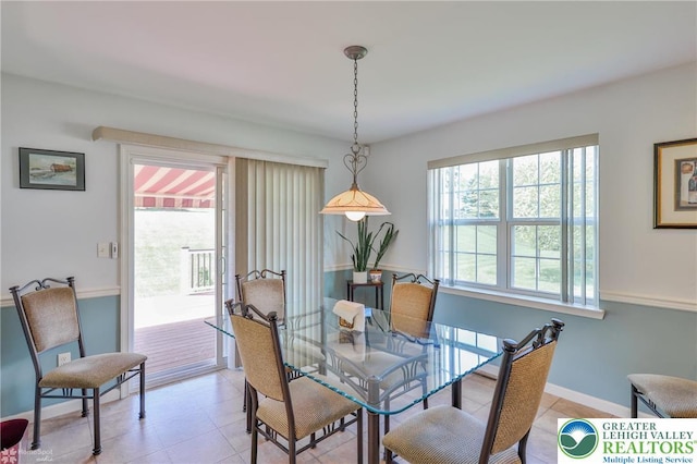 dining space featuring light tile patterned flooring and baseboards
