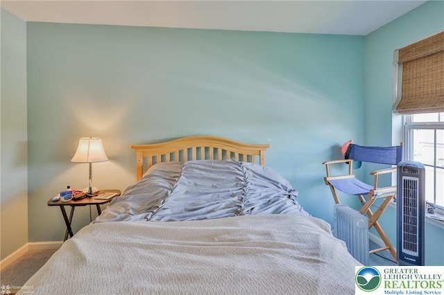 carpeted bedroom with baseboards and radiator