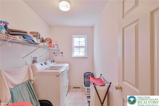 laundry room featuring washing machine and clothes dryer, light flooring, and baseboards