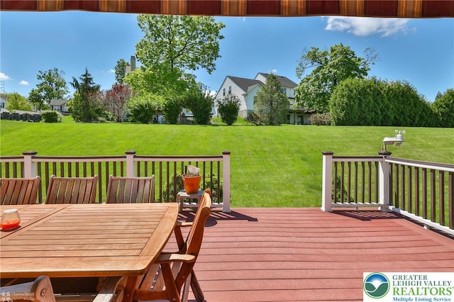 wooden terrace featuring a lawn and outdoor dining space
