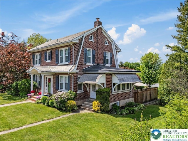 view of front of house featuring a chimney and brick siding