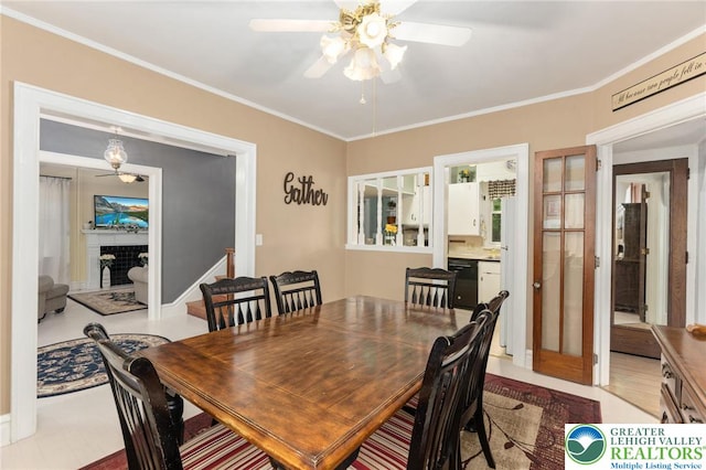 dining space with ceiling fan, crown molding, and a fireplace