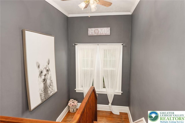stairway featuring baseboards, ceiling fan, ornamental molding, and wood finished floors