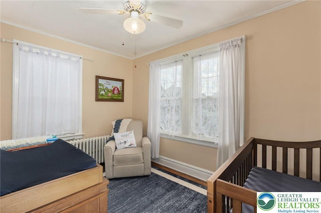 bedroom with ornamental molding, a crib, radiator heating unit, and a ceiling fan