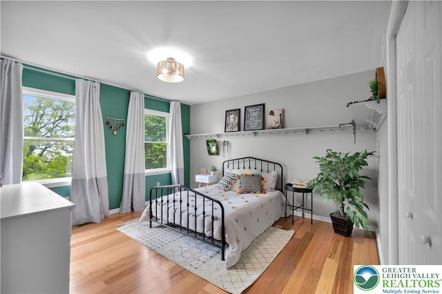 bedroom with wood finished floors and baseboards
