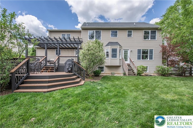 rear view of house featuring a pergola, a deck, and a lawn