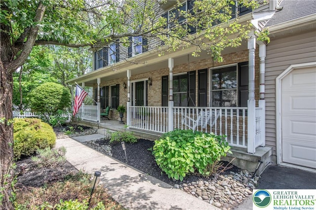 doorway to property with covered porch and brick siding