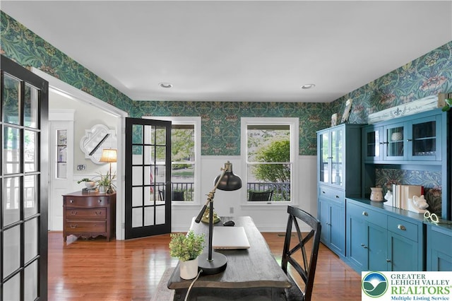 office area featuring wallpapered walls, wood finished floors, wainscoting, and french doors
