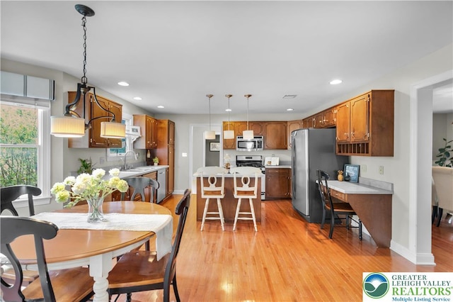 dining room with light wood-style floors, recessed lighting, and baseboards