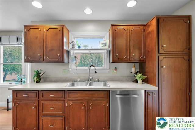 kitchen with stainless steel dishwasher, a sink, light countertops, brown cabinets, and recessed lighting
