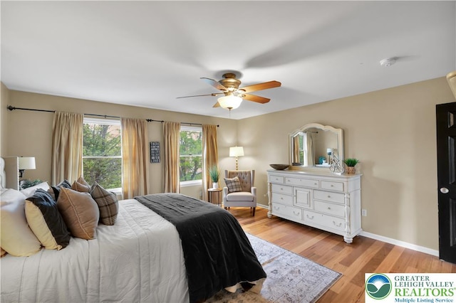 bedroom with light wood-style flooring, baseboards, and a ceiling fan