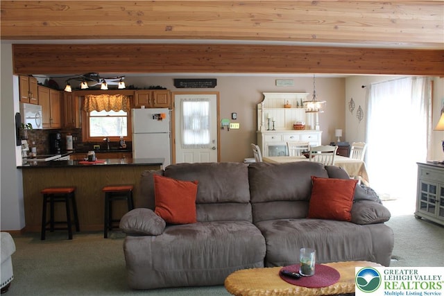 living area with light carpet and a chandelier