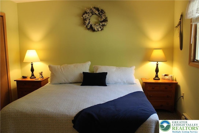 carpeted bedroom featuring a baseboard heating unit