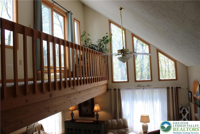 living room featuring high vaulted ceiling, a textured ceiling, and ceiling fan