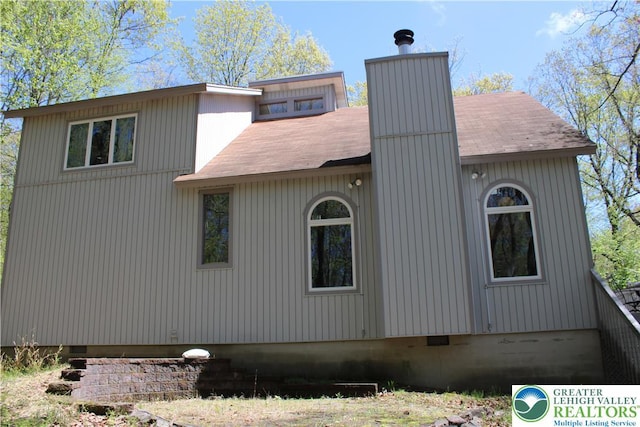 view of property exterior featuring a chimney and crawl space