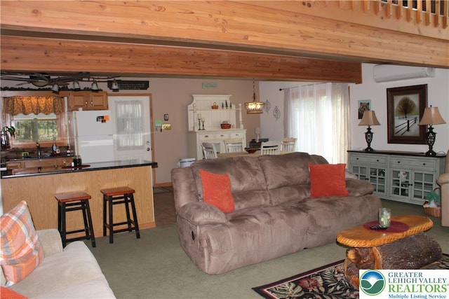 living area with a wall mounted AC, plenty of natural light, beam ceiling, a chandelier, and carpet flooring