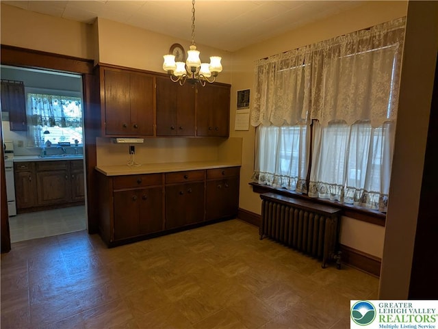kitchen featuring radiator, a chandelier, light flooring, baseboards, and light countertops