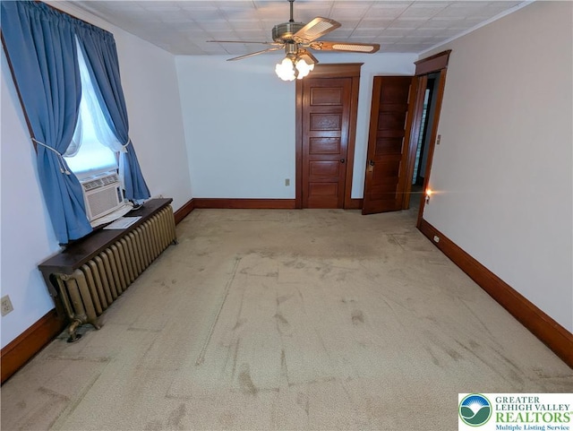 unfurnished room featuring radiator heating unit, carpet, a ceiling fan, and baseboards