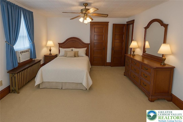 bedroom with radiator, light colored carpet, cooling unit, ceiling fan, and baseboards