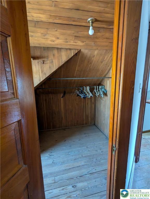 walk in closet featuring wood-type flooring and vaulted ceiling