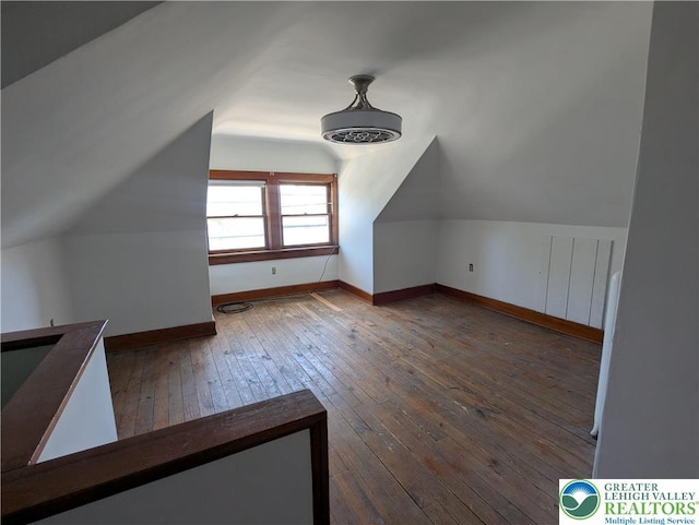bonus room featuring vaulted ceiling, hardwood / wood-style flooring, and baseboards