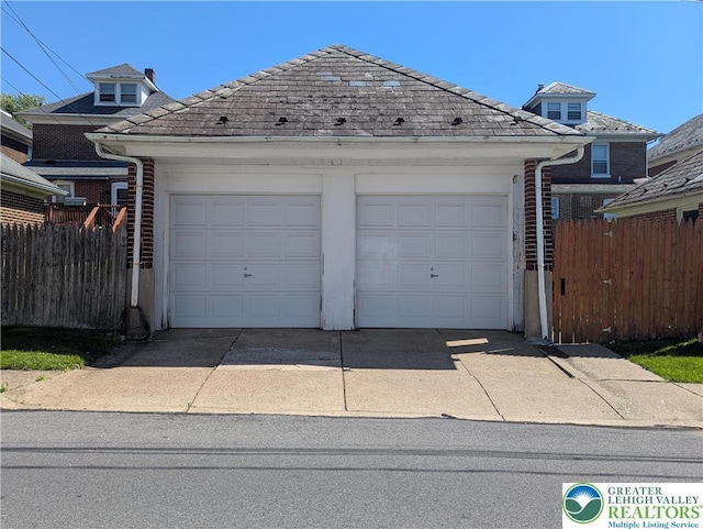garage with fence and driveway