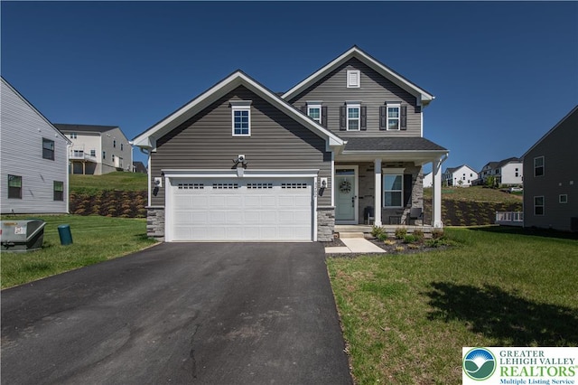 8202 Young Blvd, Upper Macungie Twp, PA 18051 - traditional-style home featuring driveway, a porch, a front yard, stone siding, and a garage