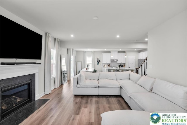 8202 Young Blvd, Upper Macungie Twp, PA 18051 - living area with a glass covered fireplace, light wood-style floors, recessed lighting, and stairway