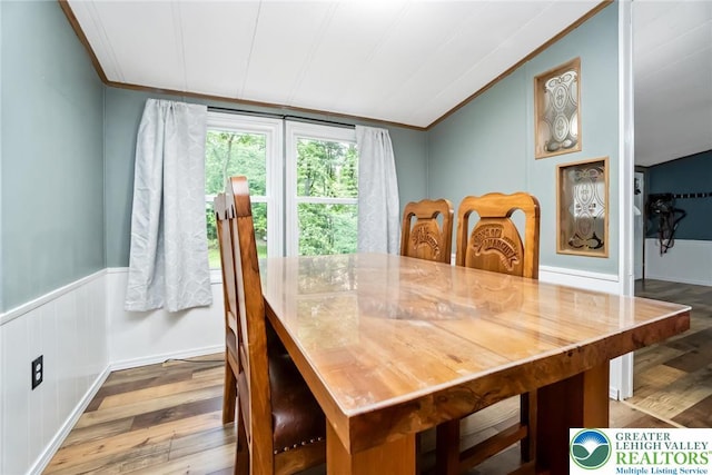 dining space featuring wood finished floors and ornamental molding