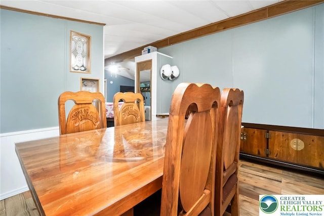 dining space with wood finished floors and a decorative wall