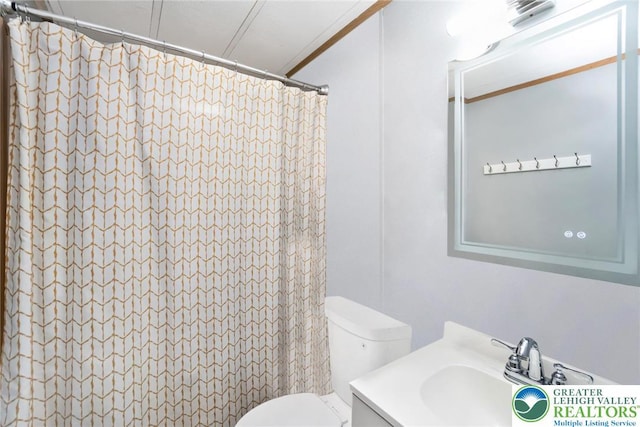 bathroom featuring toilet, a shower with curtain, and vanity