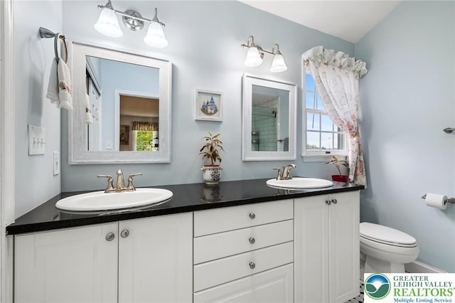 full bath featuring toilet and double vanity