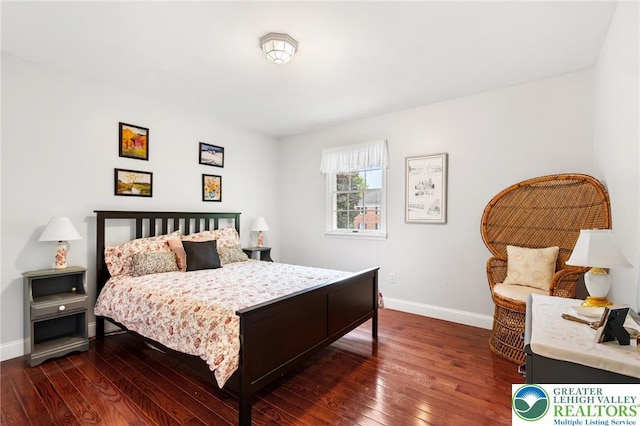 bedroom with baseboards and dark wood-type flooring