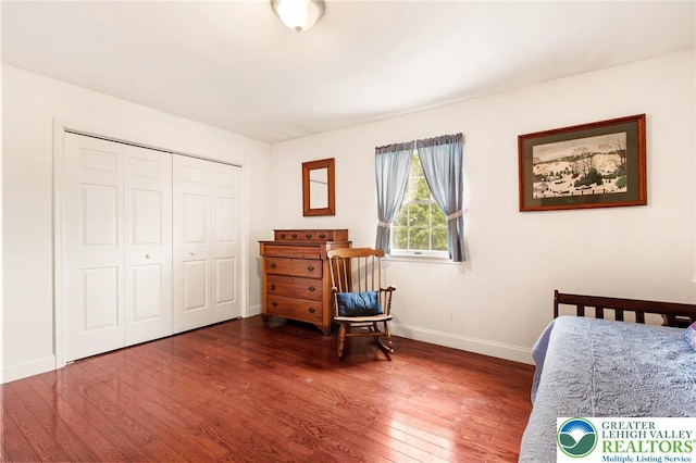 bedroom featuring hardwood / wood-style flooring, baseboards, and a closet